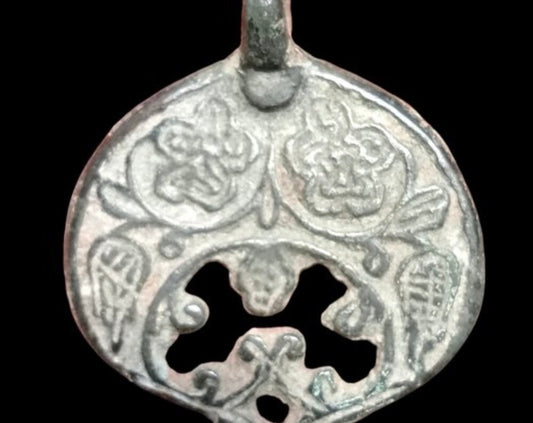 Antico amuleto medievale pendente a forma di luna con decorazioni floreali